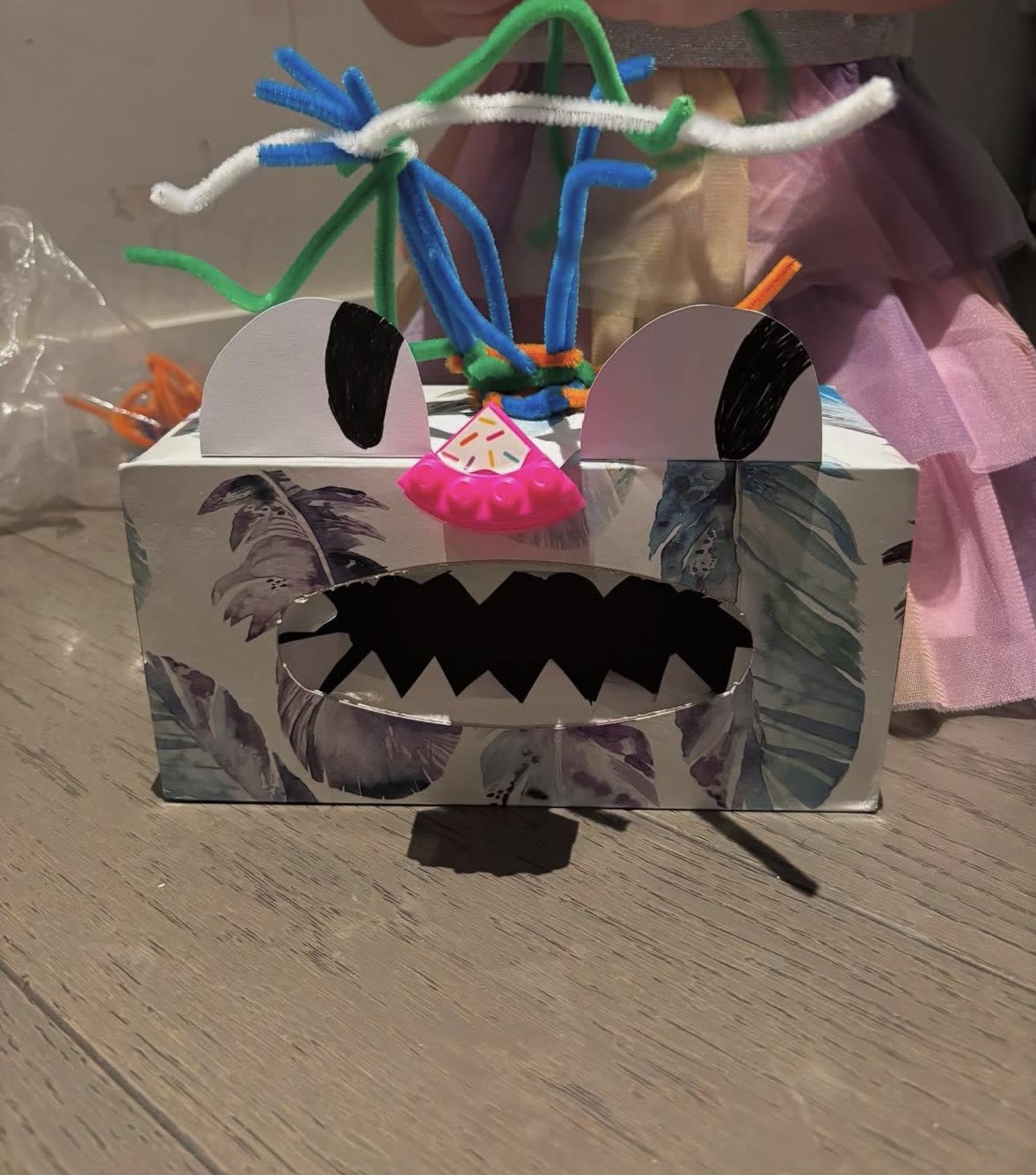 A green monster box with paper teeth and pipe-cleaner hair, made in a pop-up card workshop