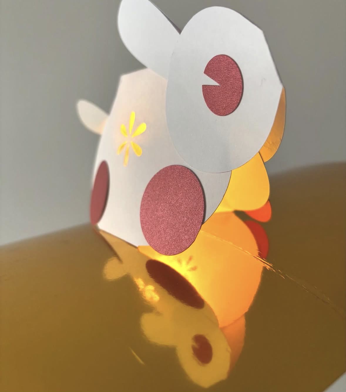 A close view of the paper rabbit pop-up card: white ears, red paper cheeks and a yellow star