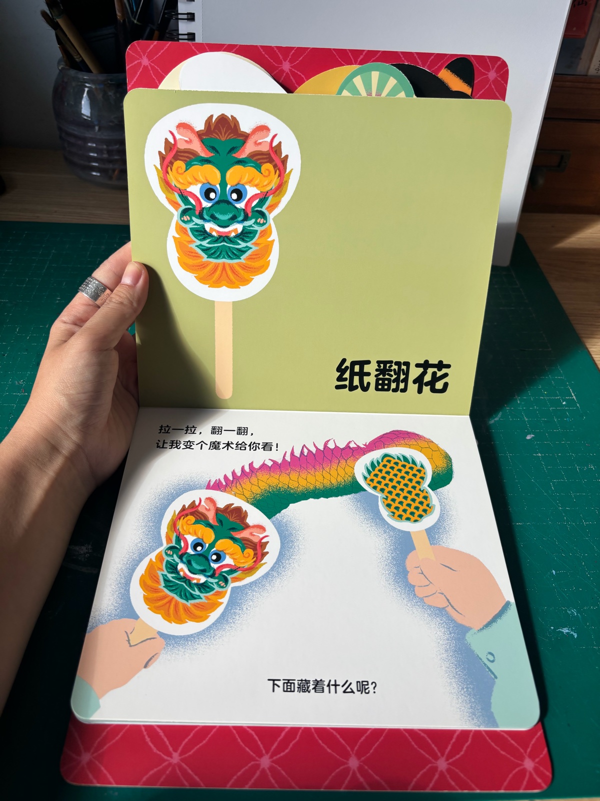 《百宝箱》 opened at the paper-flower page, with a lion-dance pop-up